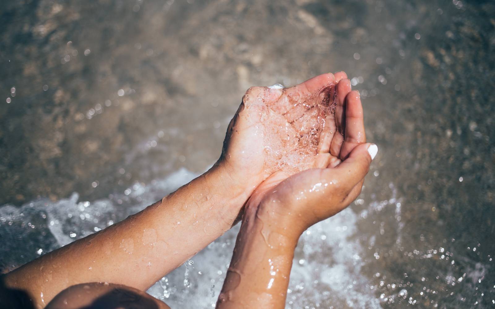 Person cupping water in their hands